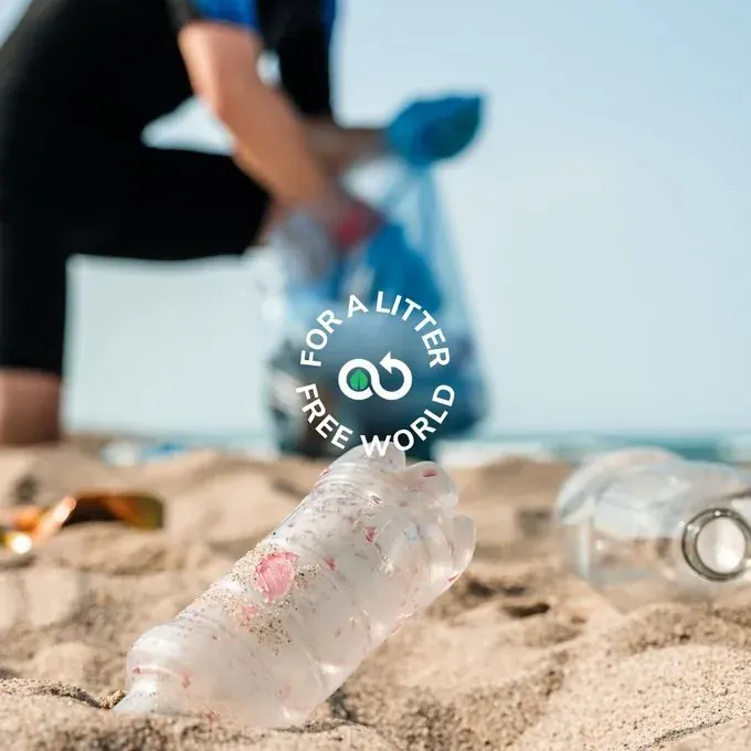 Volunteer cleaning littered beach with plastic bottle in foreground, representing NGO cleanup tracking efforts
