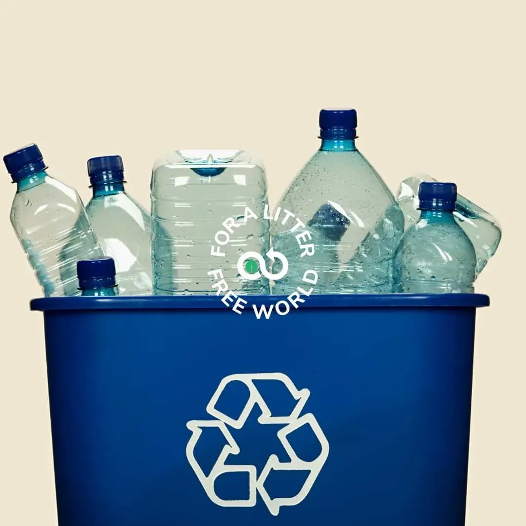 Plastic bottles collected in a blue recycling bin with a recycling symbol and litter-free message