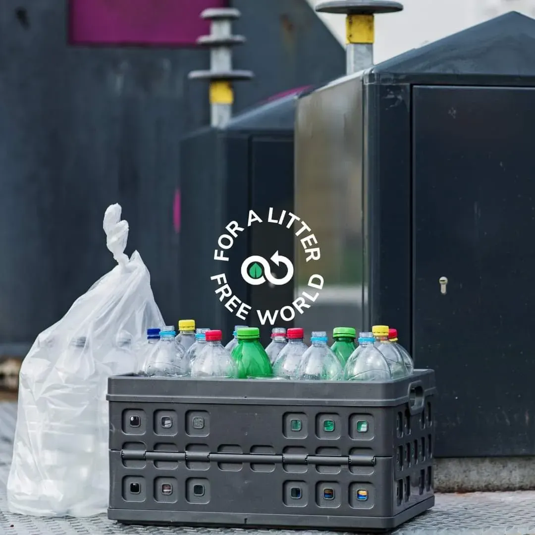 Cardboard crate of empty plastic bottles and a litter-free world logo highlighting plastic waste in the UAE